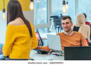 Team Working On A Digital Project. Group Of Coworkers Working In A Startup Business Environment. Employees Having Fun In A Modern Office.