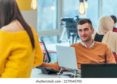 Team Working On A Digital Project. Group Of Coworkers Working In A Startup Business Environment. Employees Having Fun In A Modern Office.