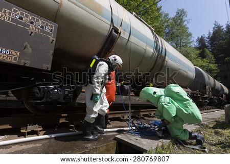 Team working with toxic acids and chemicals is securing train tanks crashed near Sofia, Bulgaria. Teams from Fire department are participating in a training with spilled toxic and flammable materials.