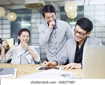 A Team Of Young Asian Entrepreneurs Having Fun While Working In Office.