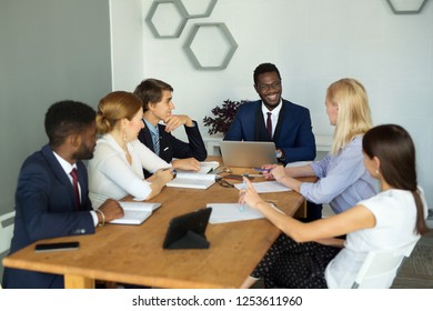 team of young businessmen men and women discuss business at work in the office at the table - Shutterstock ID 1253611960