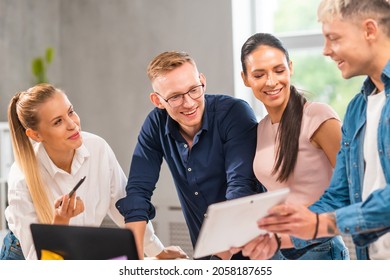 Team Of Young And Confident Startupers Is Working At The Table In The Office, Discussing The Strategy And Development Plan Of The Company. Business, Innovation, Brainstorming And Teamwork.