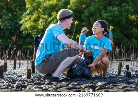 Team of young and diversity volunteer worker group enjoy charitable social work outdoor in cleaning up garbage project at the Florida mangrove forest