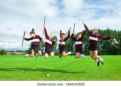 Team Of Young Girl Hockey Players Jumping On-field Celebrating The Victory.