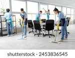 Team of young janitors cleaning in office