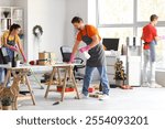 Team of young janitors cleaning in office after New Year party