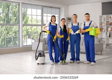 Team of young janitors with cleaning supplies in room - Powered by Shutterstock