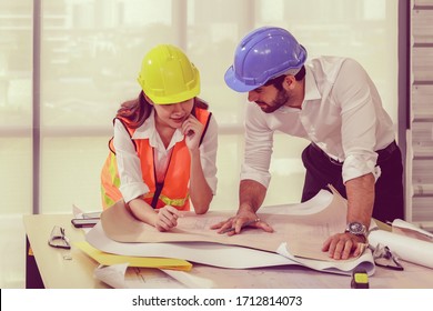 Team Of Young Man And Woman Engineer And Architects Meeting,working, Discussing,planing,designing, Measuring Layout Of Building Blueprints In Construction Site Floor At Factory.top View & Copy Space