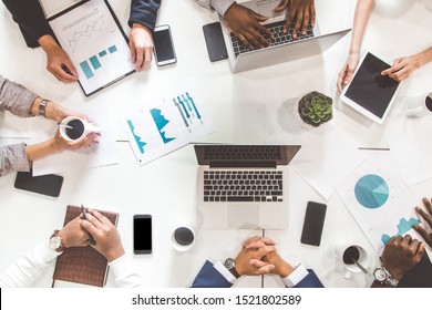 A team of young office workers, businessmen with laptop working at the table, communicating together in an office. Corporate businessteam and manager in a meeting. coworking. - Shutterstock ID 1521802589