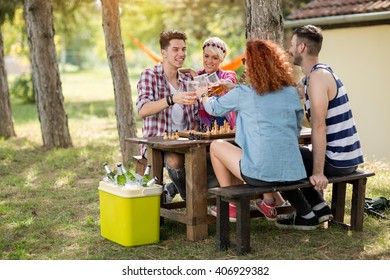 Team junger Leute, die Spaß haben und Schach im Sommerlager in Holz spielen