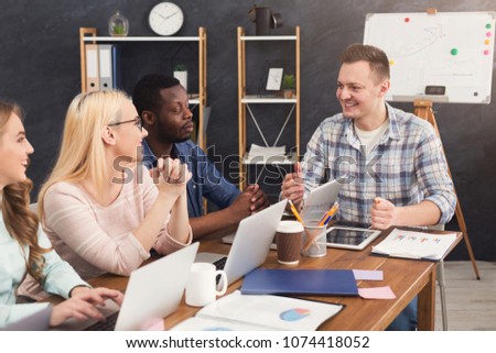 Team of young programmers with teamleader working in software developing company, discussing new project, copy space
