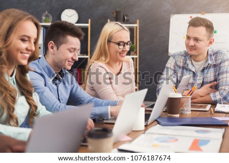Team of young programmers with teamleader working in software developing company, discussing new project, copy space