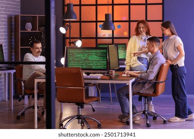 Team of young programmers working in office at night