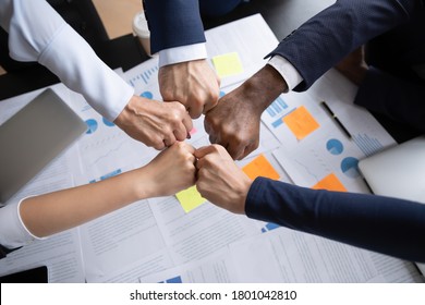 Teambuilding. Close Up Of Multiethnic Business Team Bumping Fists Above The Table With Documents In Office Showing Collaboration, Support, Unity, Partnership, Motivation And Effective Work Together