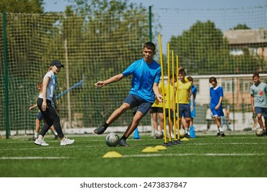 Teamwork and Agility. Young soccer players in uniforms raining outdoors on football field with coach, growing skills and endurance. Concept of sport, school, childhood, hobby, active lifestyle - Powered by Shutterstock