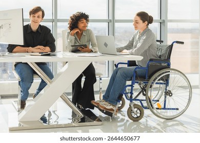Teamwork brainstorm. Diverse multiracial colleagues woman in chair for people with disability working together. Group of people sitting in creative office discussing business. Young professional team
