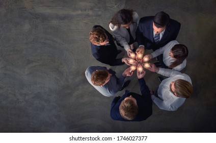 Teamwork und Brainstorming Konzept mit Geschäftsleuten, die eine Idee mit einer Lampe teilen. Konzept des Starts