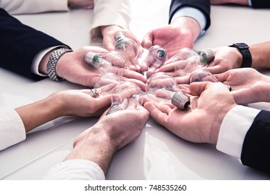 Teamwork and brainstorming concept with businessmen that share an idea with a lamp. Concept of startup - Shutterstock ID 748535260