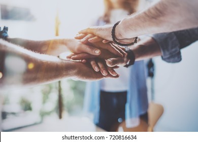 Teamwork business concept.Close up view of group of three coworkers join hand together during their meeting. Horizontal.Blurred background