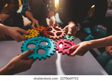 Teamwork of business people work together and combine pieces of gears - Shutterstock ID 2270669753