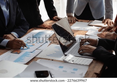 Teamwork with businessman analyzing cost graphs on table at conference room.