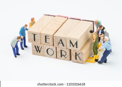 Teamwork Concept Idea, Miniature People Figurine Work As Team Helping Each Other To Build Or Develop Wooden Stamp Combine The Word Team Work, Challenge For Business Success.