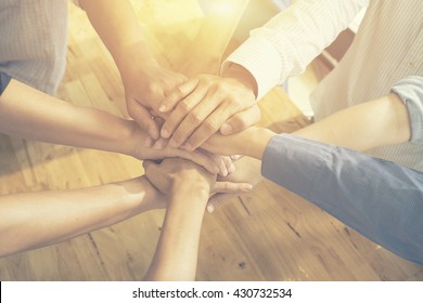 Teamwork concept,Business team standing hands together in the loft office.people joining  for cooperation success business,win in every thing,vintage color