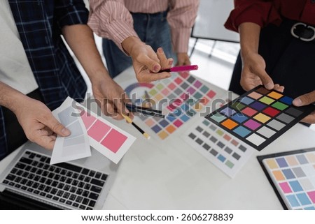 Teamwork and Design Ideation. Creative professionals collaborating on color choices to elevate their project outcomes.