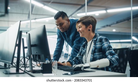 Teamwork In Diverse Office: Smiling Project Manager Talks with Happy Woman with Disability with Prosthetic Arm to Work on Desktop Computer. Professionals Create e-Commerce Software App Solution - Shutterstock ID 2083343701