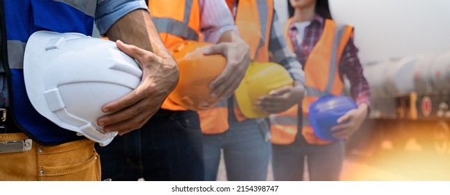 Teamwork of diversity engineer holding helmet standing in row on site work at train garage, banner cover digital design. - Shutterstock ID 2154398747