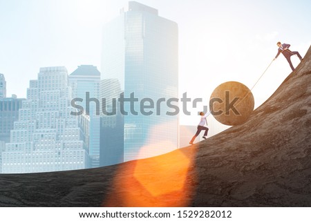 Teamwork example with business people pushing stone to top