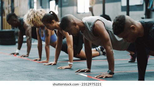 Teamwork, fitness and people do push up in gym for training, exercise and workout class. Health, sports club and serious group of men and women body builders for challenge, wellness and strength - Powered by Shutterstock