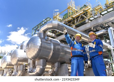 teamwork: group of industrial workers in a refinery - oil processing equipment and machinery  - Powered by Shutterstock