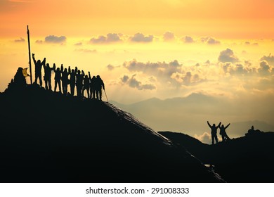 Teamwork. A group of people are standing on the top of the mountain. 