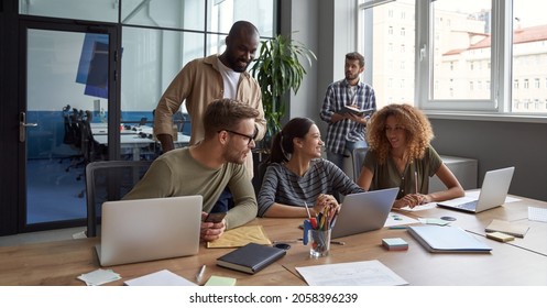 Teamwork. Group of young happy multicultural business people working together in modern office, communicating and sharing fresh ideas - Powered by Shutterstock