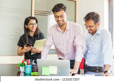 Teamwork in Indian office. Three people working on laptop