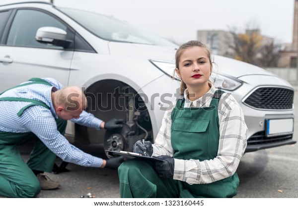 Teamwork on\
car service station, brake disk\
checking