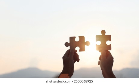 Teamwork and partnership concept. Hands are raised against a bright, white sky, each holding a piece of a wooden jigsaw puzzle. teamwork, problem-solving, Charity, volunteer. Unity, team business. - Powered by Shutterstock