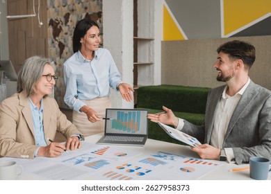 Teamwork process. Business people pointing at business document during discussion at meeting. Business people meeting explaining the financial graph data and marketing plan.