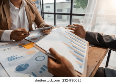 Teamwork process, Business team using a tablet to calculate the numbers of statistic business profits growth rate on documents graph data, desk in the office