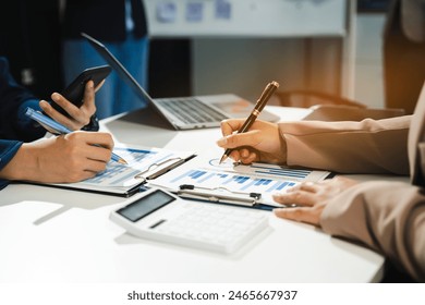 Teamwork process, Business team using a calculator to calculate the numbers of statistic business profits growth rate on documents graph data, desk in the office.