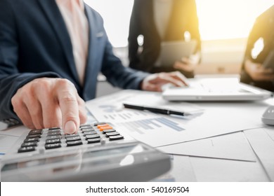 Teamwork process, Business team using a calculator to calculate the numbers of statistic business profits growth rate on documents graph data, his desk in a office. - Shutterstock ID 540169504