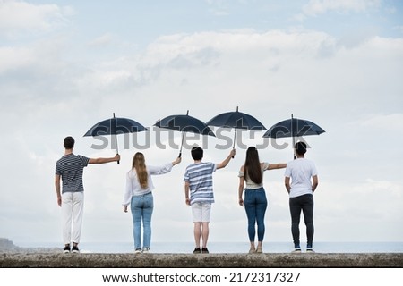Teamwork and sacrifice concept. Group of people covering each other with umbrellas