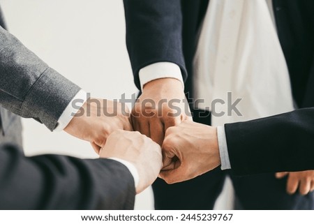 Teamwork, team building, responsibility and equal opportunities. Hand holding together bumping fists in circle as unity symbol.