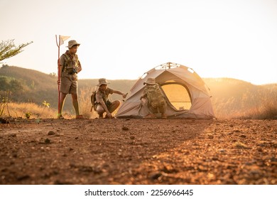 Teamwork of Three Boy Scouts attending Scout camp pitching their tents in a Boy Scout camp on a mountain near sunset. - Shutterstock ID 2256966445