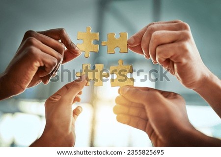 Teamwork, unity, collaboration by a group of business people completing a puzzle together, innovation and strategy. Closeup of hands planning, sharing a goal or vision while joining in success