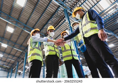 Teamwork unity concept, Group of industrial worker in medical mask and safety suite hand stack celebrate successful or deal commitment