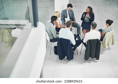 Teamwork, working together and strategy with a female leader and group or team of business people and colleagues talking in a meeting. Discussing plans and ideas in a workshop or seminar from above - Shutterstock ID 2188929615