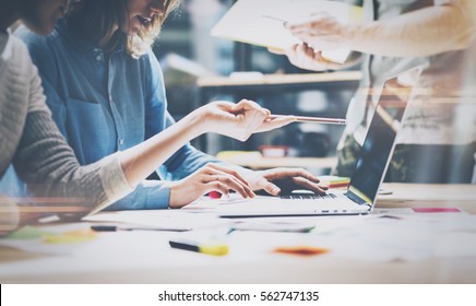 Teamwork,brainstorming concept.Young creative managers team working with new startup project in modern office. Contemporary notebook on wood table.Horizontal, film effect - Shutterstock ID 562747135