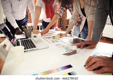 Teamwork,brainstorming concept.Young creative managers team working with new startup project in modern office. Contemporary notebook on wood table.Horizontal